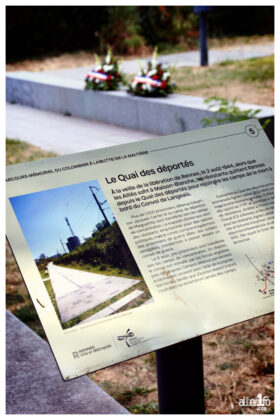 photo prise du quai des déportés, quartier courrouze. gerbes de fleurs en arriere plan
